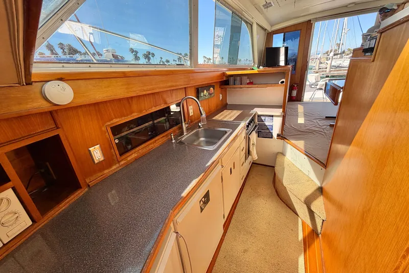 Slide: The Image of Interior of a 1974 Bertram 46 Convertible yacht featuring a compact kitchen area. - 17