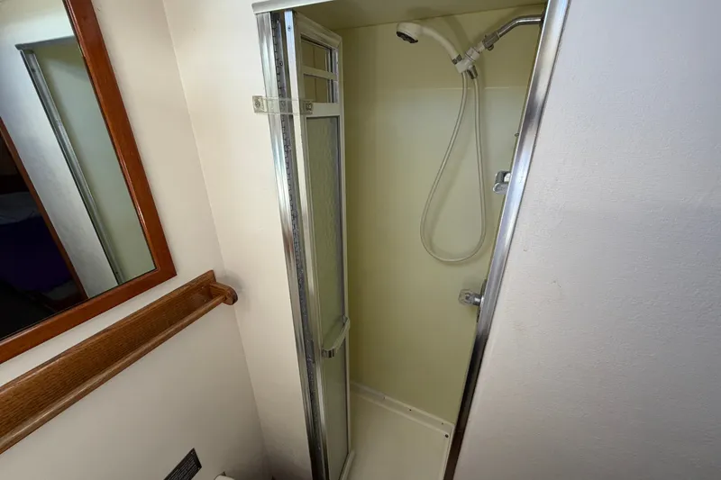 Slide: The Image of Shower area inside a 1974 Bertram 46 Convertible boat, featuring a compact design. - 26