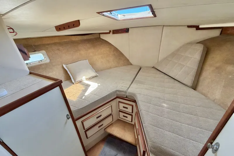 Slide: The Image of 1974 Bertram 46 Convertible cabin interior with cozy bedding and storage drawers. - 25