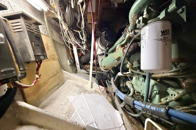 Slide: The Image of Engine room of a 1974 Bertram 46 Convertible boat, showcasing wiring and machinery. - 28