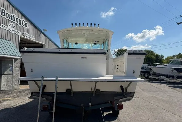 Slide: The Image of 2003 Baha Cruisers 277 GLE boat at a dealership, rear view under clear sky. - 20