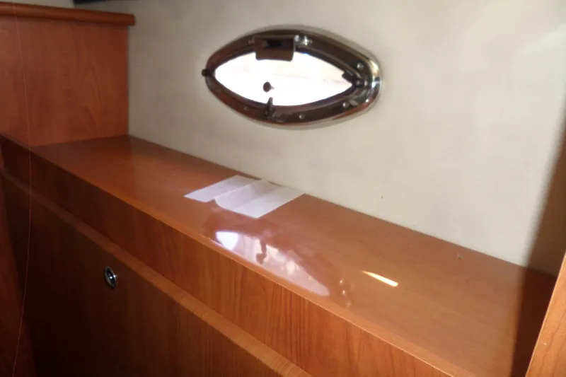 Slide: The Image of Interior of 2008 Bayliner 320 Cruiser with wooden cabinetry and oval porthole window. - 48