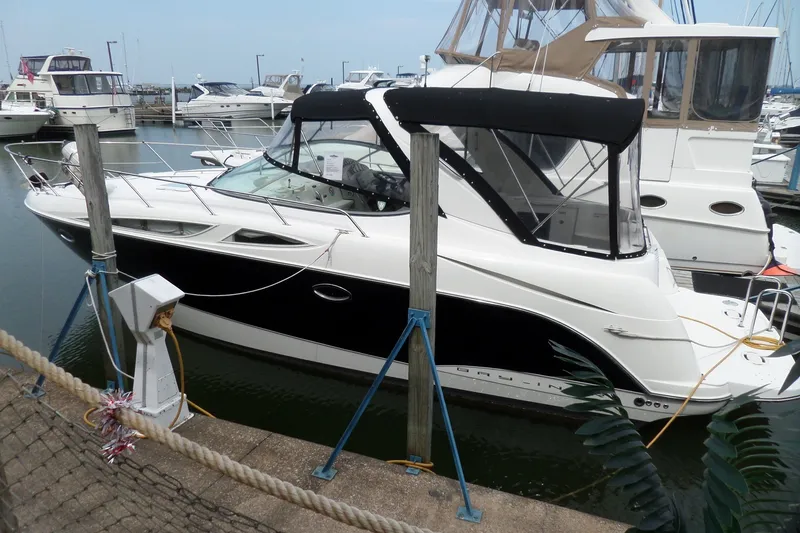 The Image of 2008 Bayliner 320 Cruiser docked at marina, featuring sleek black and white design. - 0
