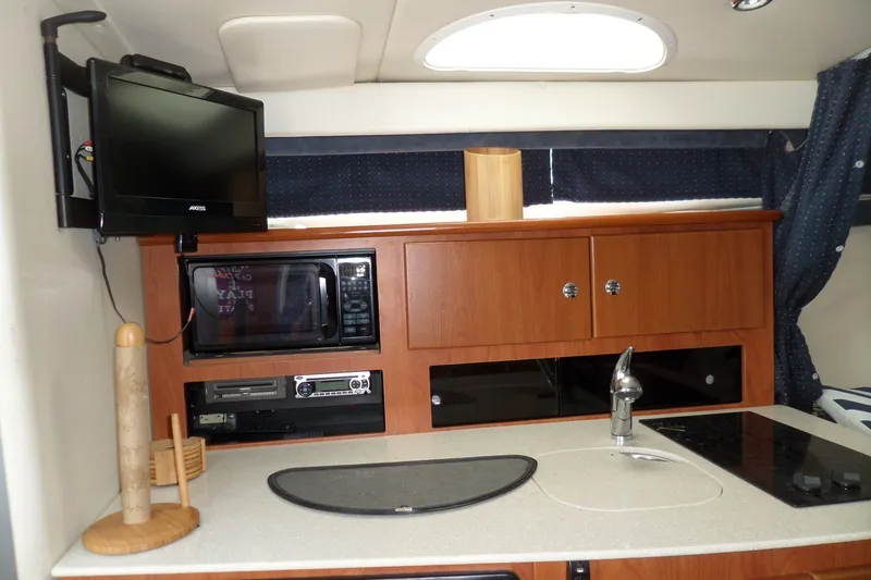 Slide: The Image of Interior of 2008 Bayliner 320 Cruiser with kitchenette, TV, and microwave. - 29