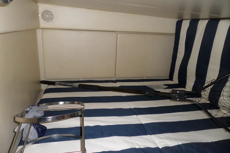 Slide: The Image of Interior cabin of 2008 Bayliner 320 Cruiser with striped bedding and fishing net. - 45