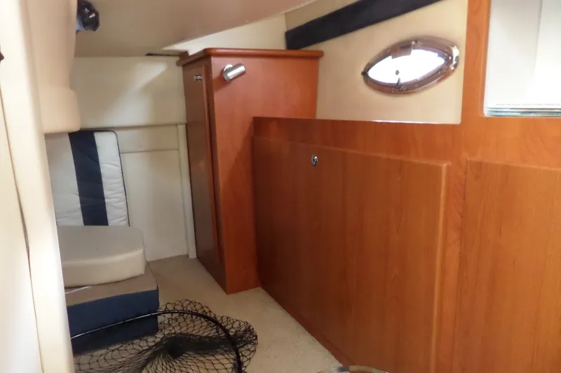 Slide: The Image of 2008 Bayliner 320 Cruiser cabin interior with wood paneling and seating area. - 43