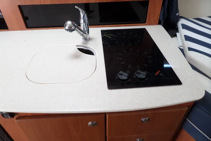 Slide: The Image of 2008 Bayliner 320 Cruiser kitchen with sink and stovetop, featuring modern design. - 52