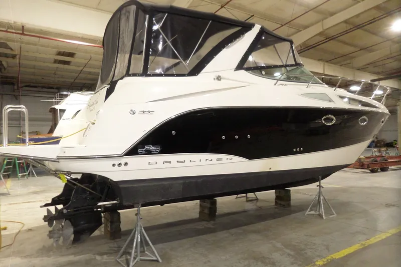 Slide: The Image of 2008 Bayliner 320 Cruiser in a warehouse, elevated on stands for maintenance. - 3
