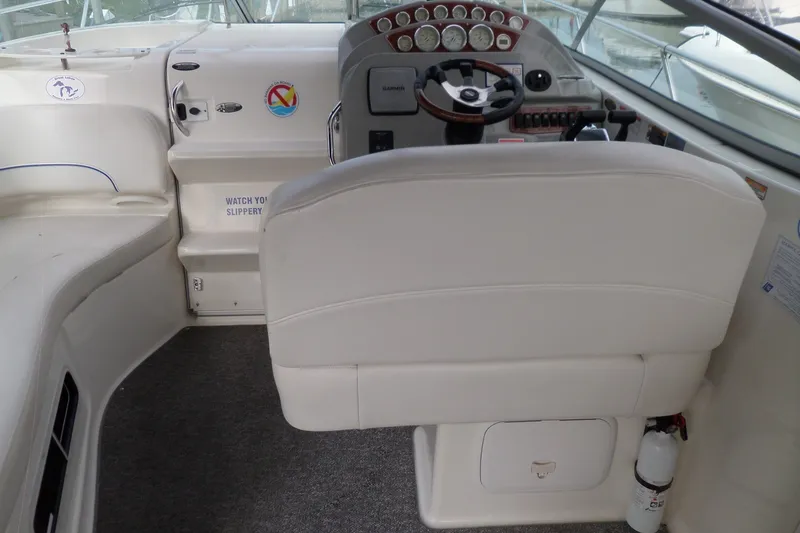 Slide: The Image of 2008 Bayliner 320 Cruiser cockpit with steering wheel, gauges, and white seating. - 19