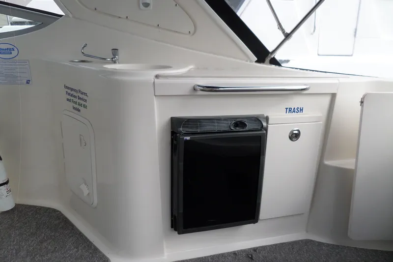Slide: The Image of 2008 Bayliner 320 Cruiser interior with sink, trash compartment, and storage. - 23