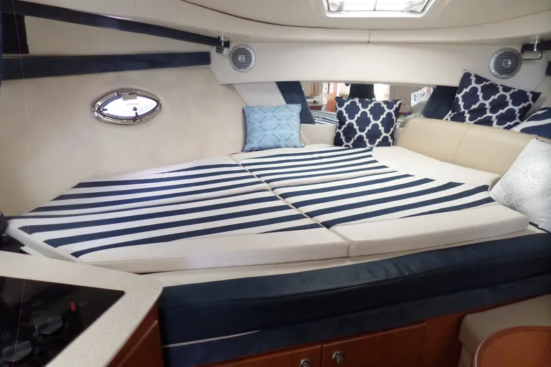 Slide: The Image of Interior of 2008 Bayliner 320 Cruiser with striped bedding and decorative pillows. - 26