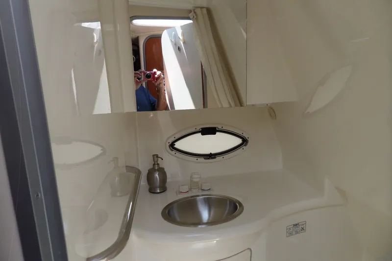 Slide: The Image of 2008 Bayliner 320 Cruiser bathroom with sink, mirror, and porthole window. - 40
