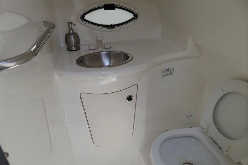 Slide: The Image of 2008 Bayliner 320 Cruiser bathroom with sink, toilet, and porthole window. - 39