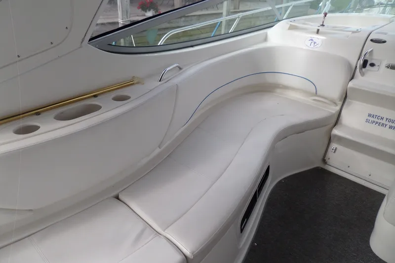 Slide: The Image of Interior seating of 2008 Bayliner 320 Cruiser with white upholstery and cup holders. - 18