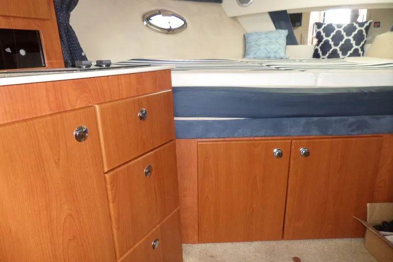 Slide: The Image of Interior of 2008 Bayliner 320 Cruiser with wood cabinetry and cozy bedding. - 28