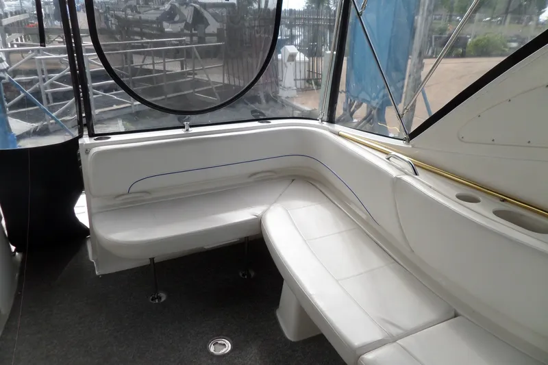 Slide: The Image of 2008 Bayliner 320 Cruiser interior seating area with white upholstery and window views. - 16