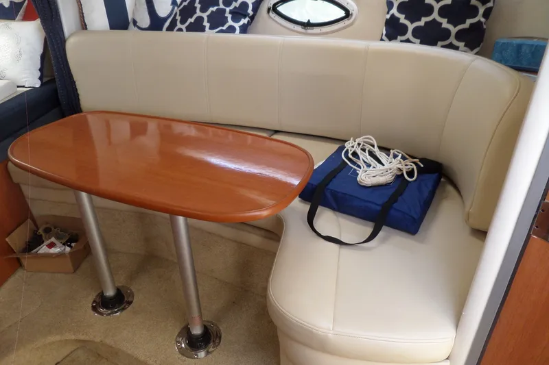 Slide: The Image of Interior of 2008 Bayliner 320 Cruiser with beige seating and wooden table. - 49