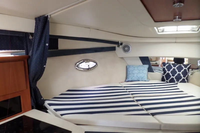 Slide: The Image of Interior of 2008 Bayliner 320 Cruiser with striped bedding and decorative pillows. - 25