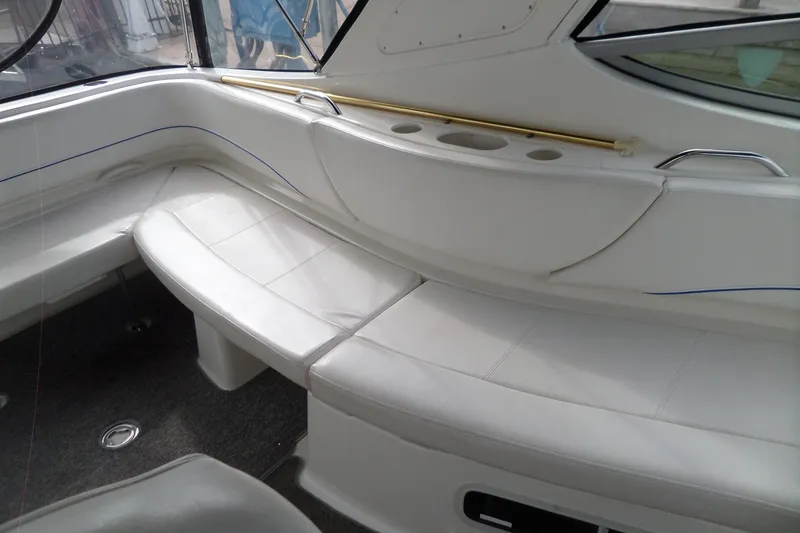 Slide: The Image of 2008 Bayliner 320 Cruiser interior with white seating and cup holders. - 17