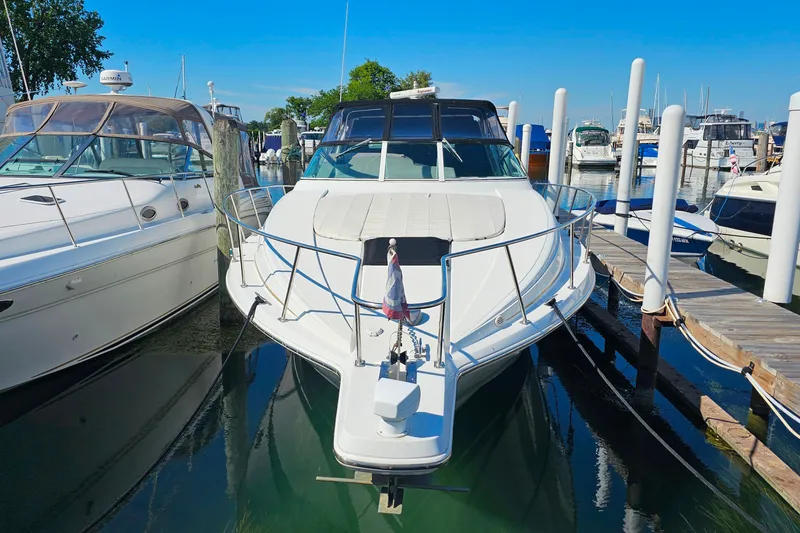 Slide: The Image of 1998 Trojan 400 Express yacht docked at marina, surrounded by other boats. - 42