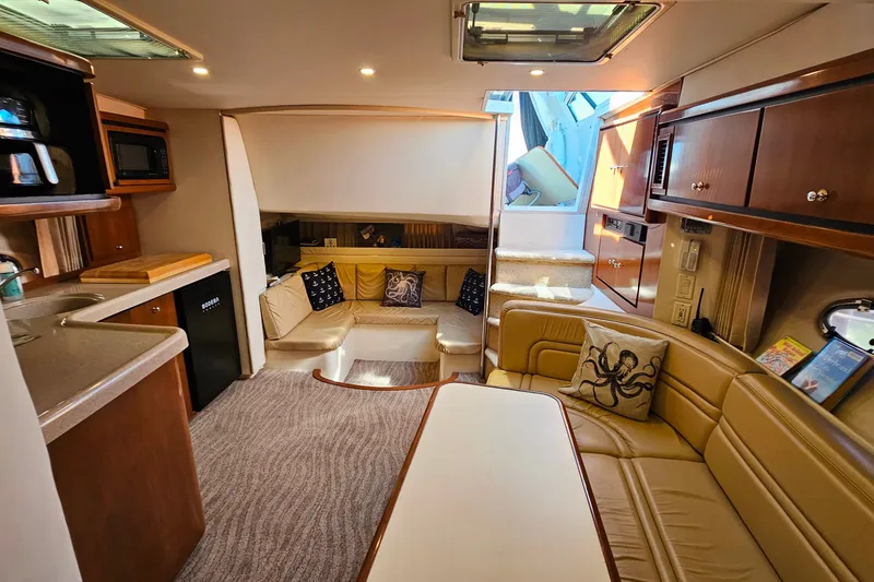 Slide: The Image of 1998 Trojan 400 Express yacht interior with cozy seating, kitchenette, and elegant wood finishes. - 36
