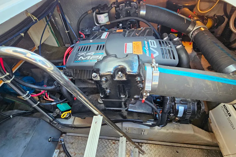 Slide: The Image of Engine compartment of a 1998 Trojan 400 Express boat, featuring a MerCruiser V8 engine. - 24