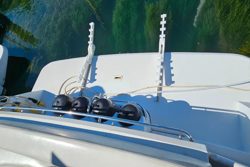 Slide: The Image of 1998 Trojan 400 Express boat deck with fishing rod holders and equipment. - 22