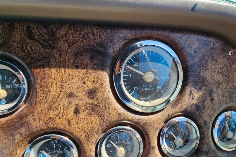 Slide: The Image of Dashboard of a 1998 Trojan 400 Express boat with wood grain finish and gauges. - 18