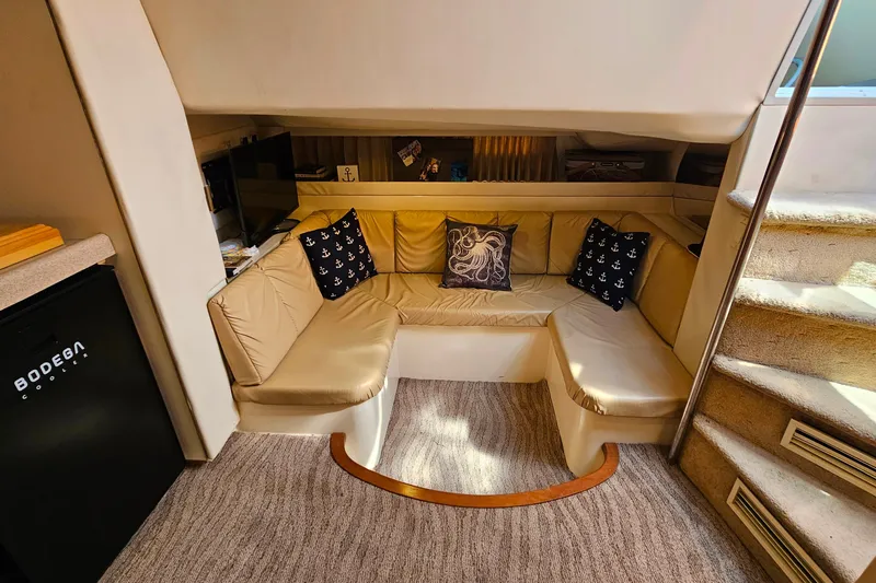 Slide: The Image of Interior of 1998 Trojan 400 Express yacht with cozy seating and nautical-themed pillows. - 32