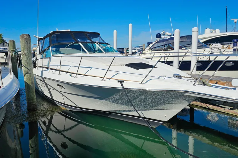 The Image of 1998 Trojan 400 Express yacht docked at marina under clear blue sky. - 0