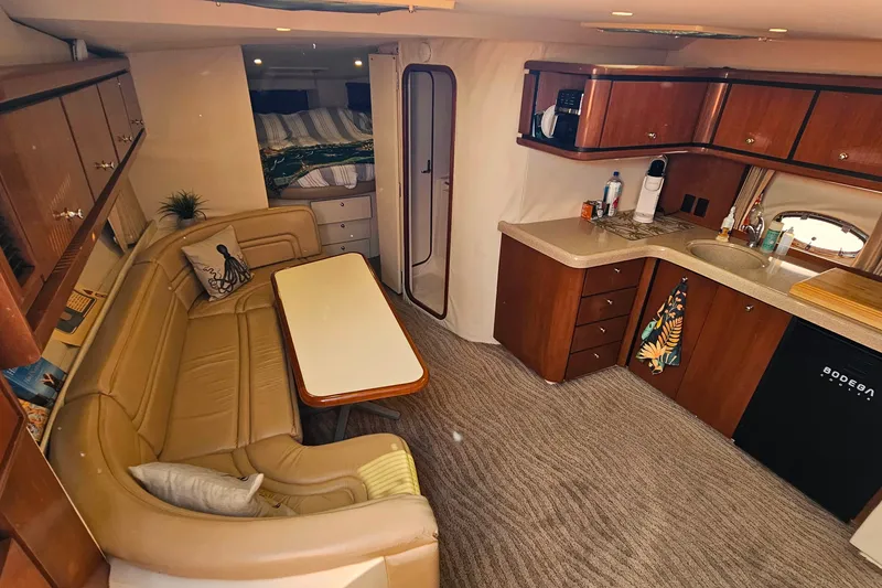 Slide: The Image of Luxurious interior of a 1998 Trojan 400 Express yacht with kitchen and seating area. - 28