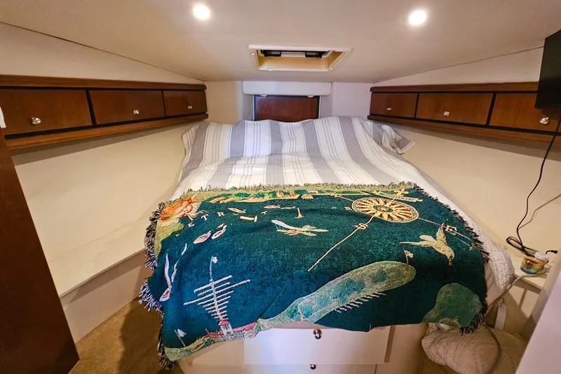 Slide: The Image of Cozy cabin interior of a 1998 Trojan 400 Express with a bed and decorative blanket. - 40