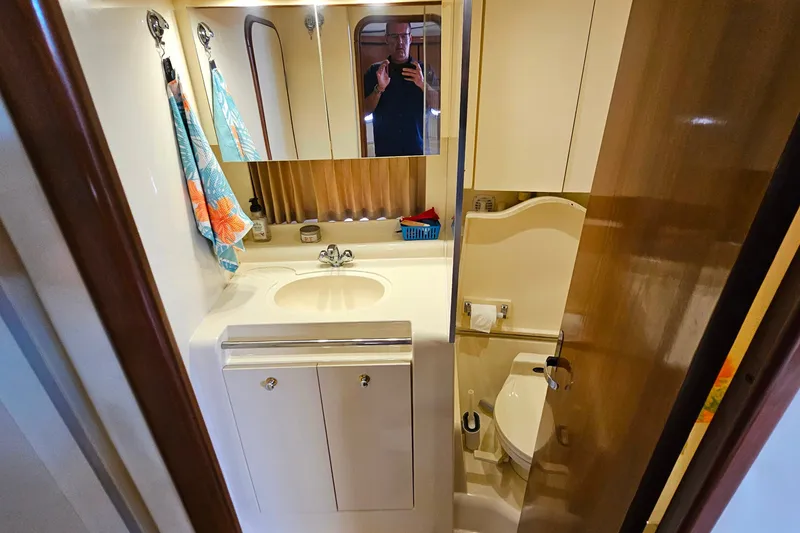 Slide: The Image of Bathroom interior of a 1998 Trojan 400 Express yacht, featuring sink and toilet. - 37