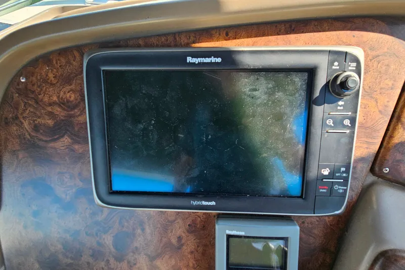 Slide: The Image of Raymarine display on 1998 Trojan 400 Express boat dashboard with wood finish. - 16