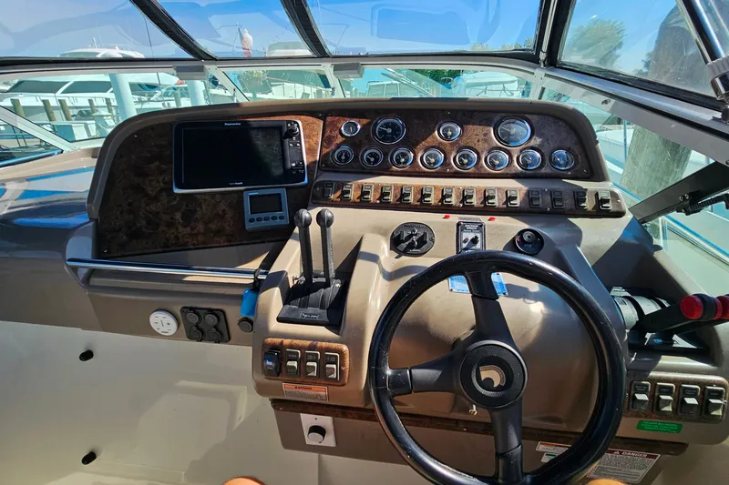 Slide: The Image of 1998 Trojan 400 Express boat dashboard with steering wheel and control panel. - 20
