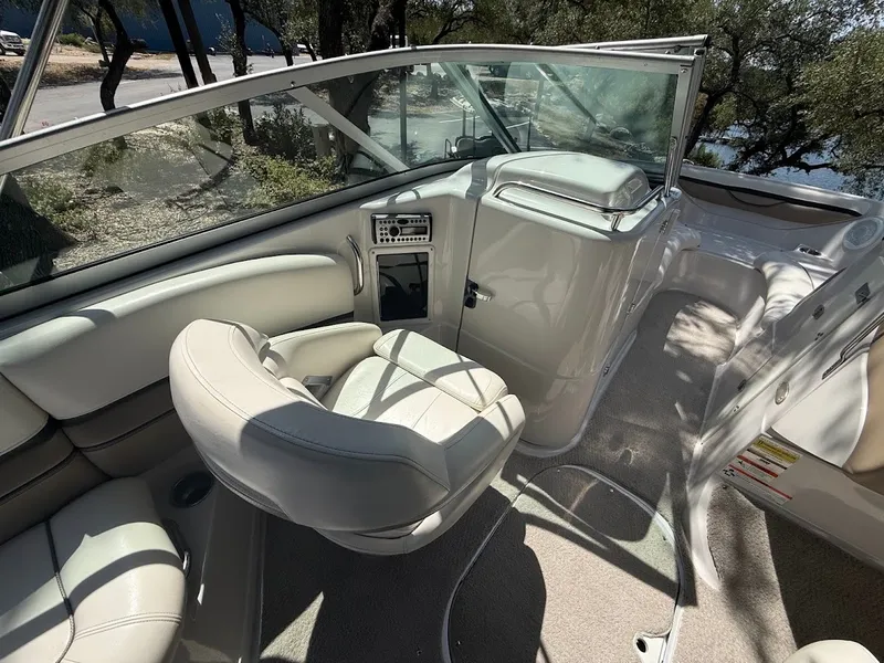 Slide: The Image of Interior of a 2006 Four Winns 240 Horizon with beige upholstery and helm console. - 13