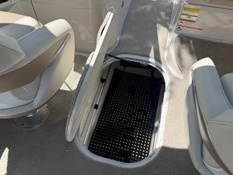 Slide: The Image of An open storage compartment in the carpeted floor of a boat with two seats. - 21