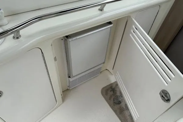 Slide: The Image of 2003 Sea Ray 380 Sundancer interior with open cabinet and mini fridge. - 15