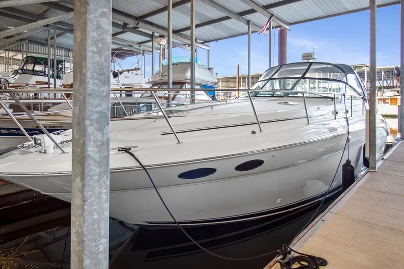 The Image of 2003 Sea Ray 380 Sundancer docked in a marina under a covered shelter. - 20