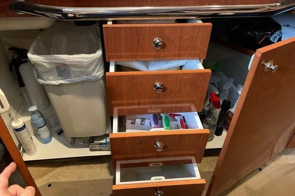 Slide: The Image of Cabinet with open drawers and cleaning supplies on a 2003 Sea Ray 380 Sundancer boat. - 32