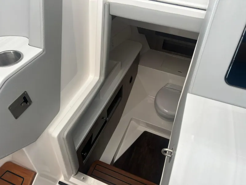 Slide: The Image of Interior view of 2022 Regal LS36 boat cabin with compact toilet area. - 25