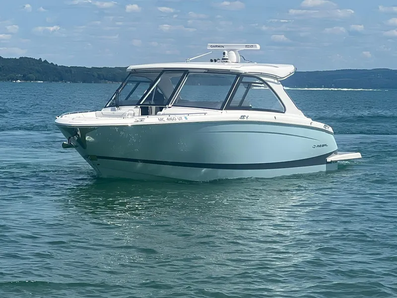Slide: The Image of 2022 Regal LS36 boat on a calm lake under a blue sky. - 2
