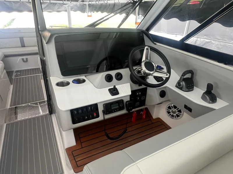 Slide: The Image of 2022 Regal LS36 boat cockpit with modern steering, controls, and wood accents. - 11