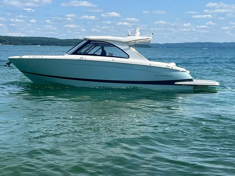 Slide: The Image of 2022 Regal LS36 boat on a sunny lake with clear skies. - 36