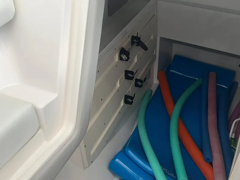Slide: The Image of Storage compartment in 2022 Regal LS36 boat with pool noodles and mats. - 31