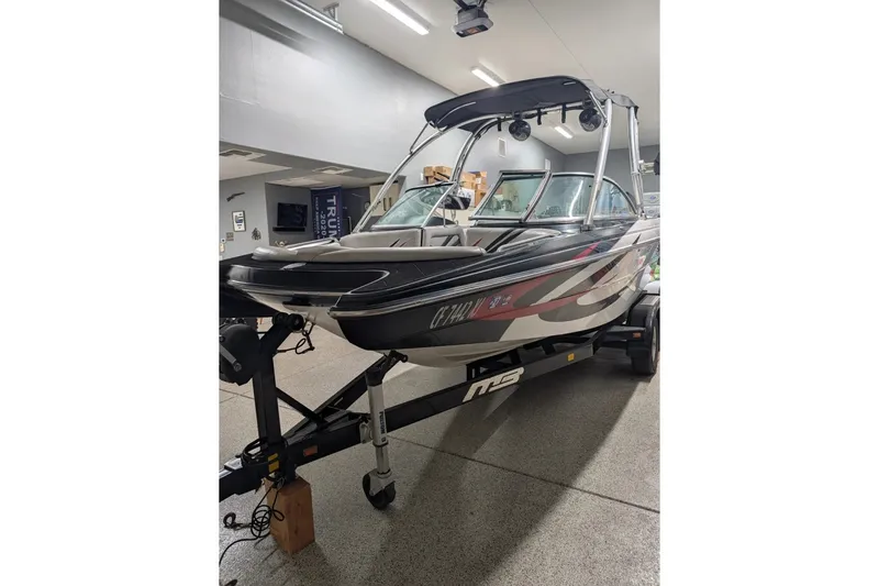 The Image of 2011 MB F21 Tomcat on a trailer inside a showroom. - 0