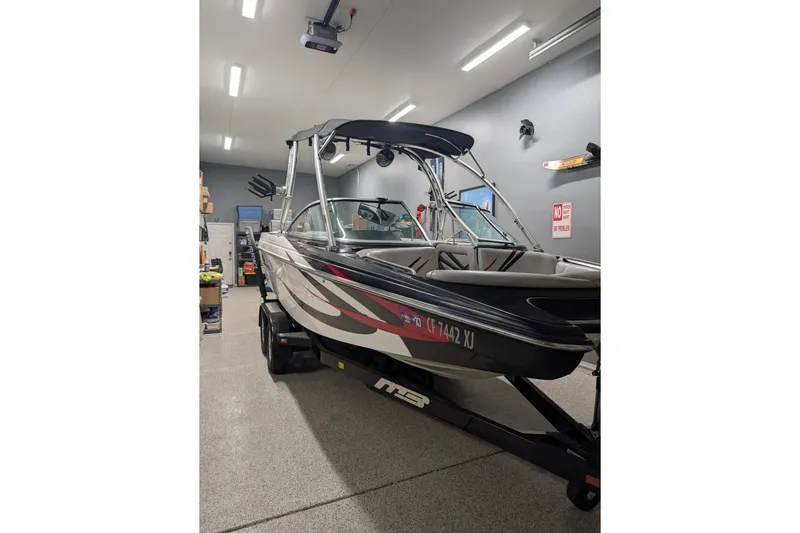 Slide: The Image of 2011 MB F21 Tomcat boat in a garage, featuring sleek design and modern graphics. - 2
