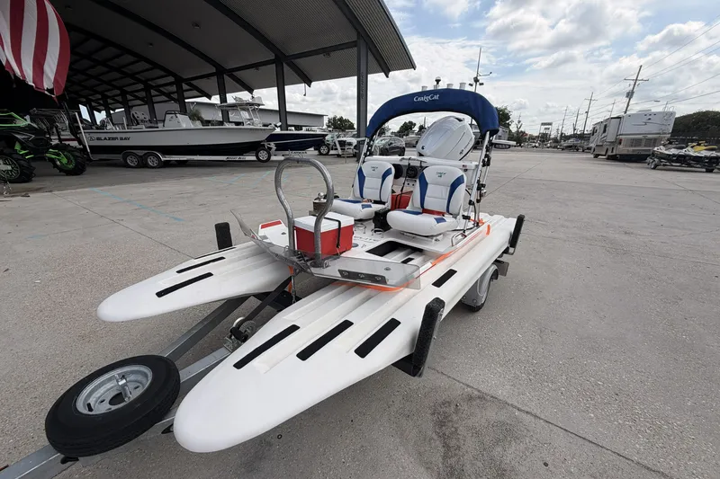 Slide: The Image of 2024 Craig Cat E2 Elite catamaran on trailer, parked outdoors under cloudy sky. - 2