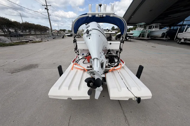 Slide: The Image of 2024 Craig Cat E2 Elite boat with outboard motor, parked on concrete surface. - 8