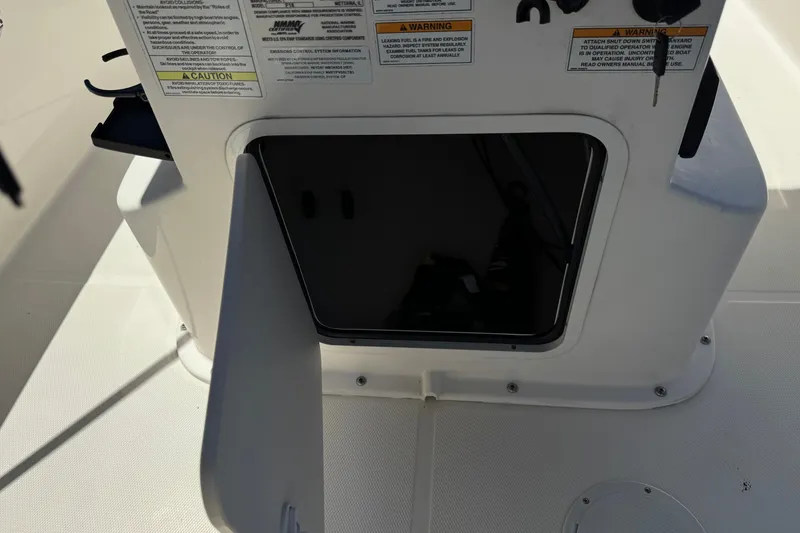 Slide: The Image of Open storage compartment on a 2022 Trophy T18 Bay boat with visible warning labels. - 24